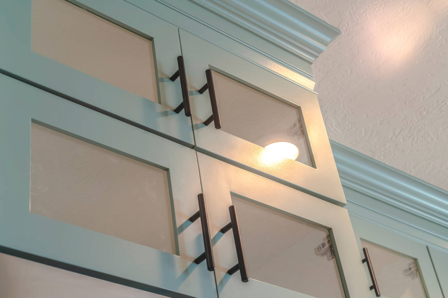 Close up of built-in overhead kitchen cupboards and handles Malaysia